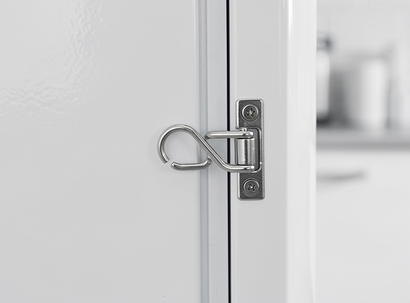 Small hook-and-eye latch mounted on the side of a white mini fridge door pulling it tight against the frame