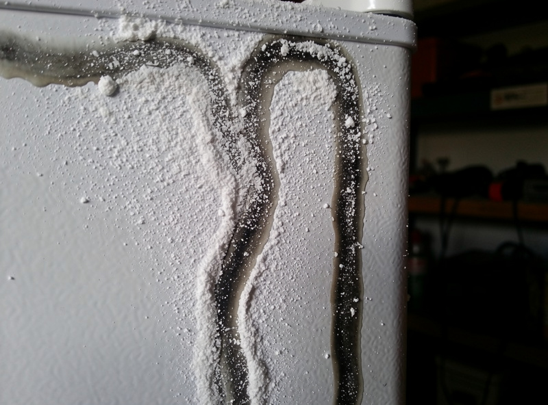 Cornstarch and alcohol slurry painted on a mini fridge side panel showing refrigerant lines as dark wet streaks against dry white powder