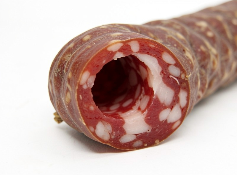 Salami casing detached and lifted from a hardened outer ring with a hollow core gap visible
