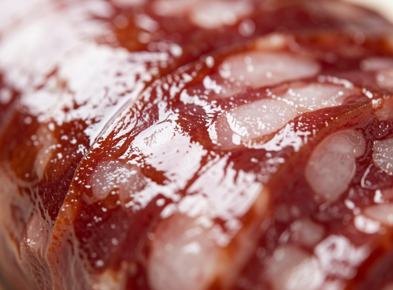 Close-up of a glossy slightly slimy sheen on a cured salami casing surface