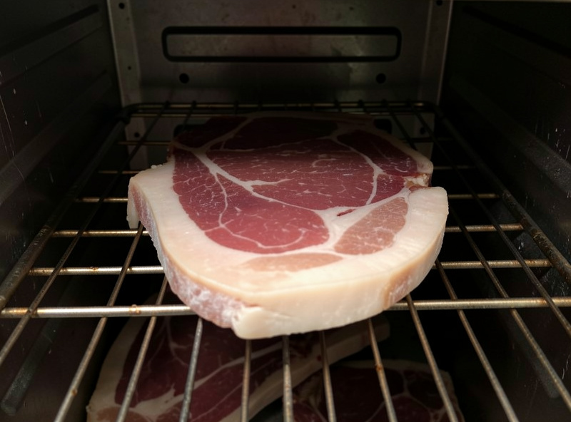Hung air-dried beef with a soft, pale under-salted appearance on a chamber rack