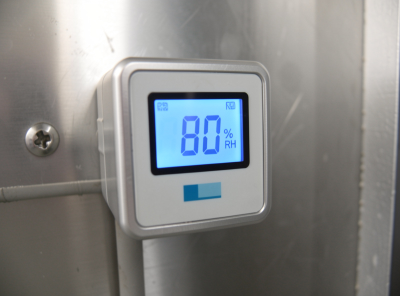 Digital humidity and temperature controller on a curing chamber reading around 80 percent RH